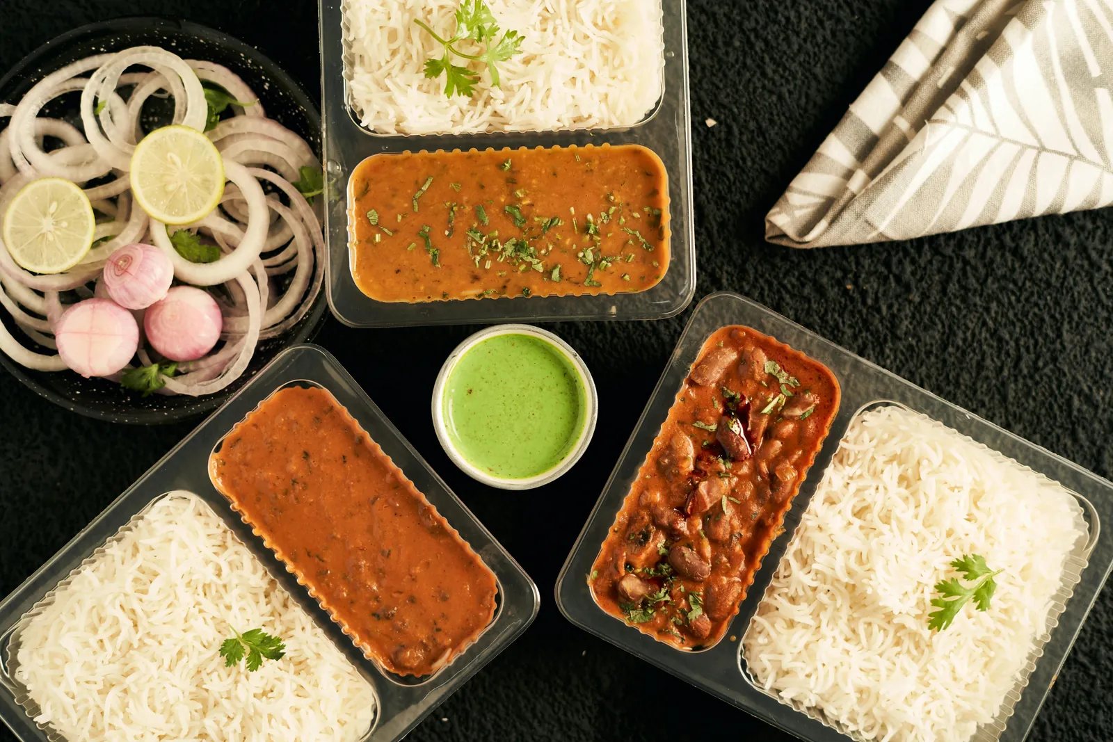Packed meal box with rice, curries and accompaniments